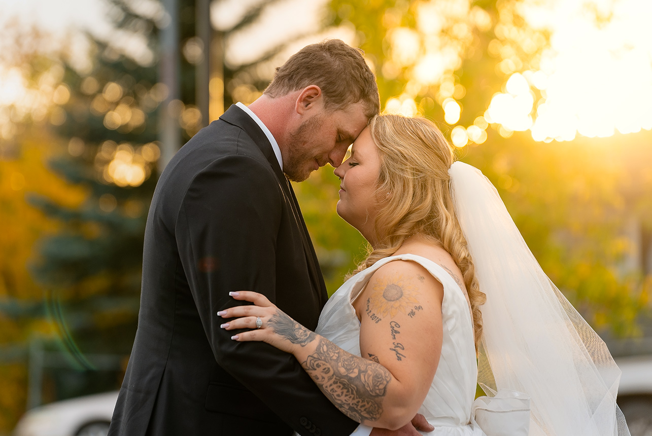 Bride and groom embracing at sunset during their outdoor wedding in Sherwood Park
