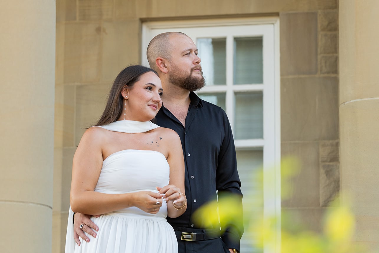 Engaged couple standing together outside Government House in Edmonton during a summer engagement session by Catriona Hope Photography