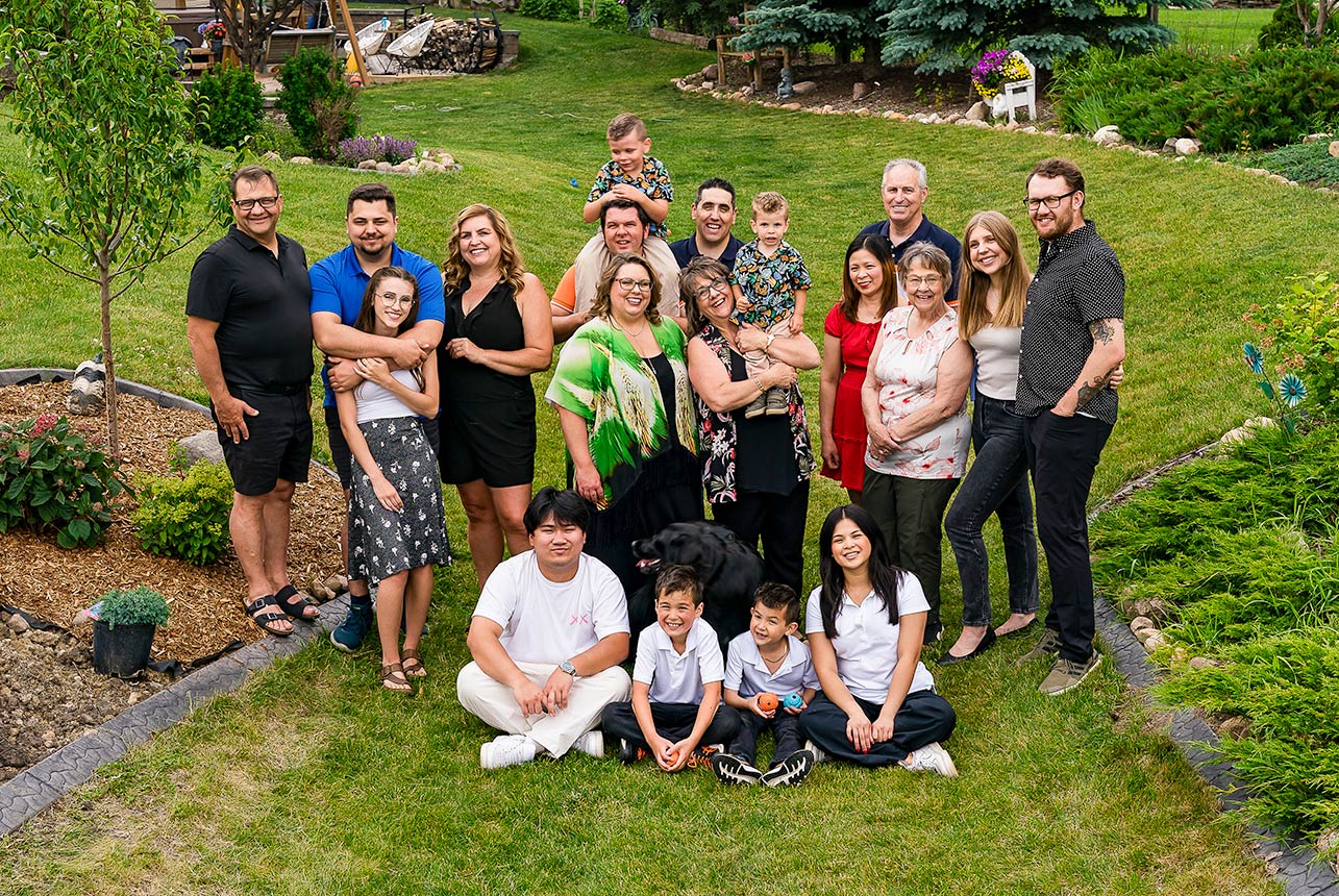 Multi generational family gathered together in a backyard during a relaxed outdoor photo session