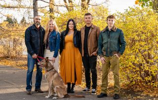 Family wearing coordinated autumn outfits during an outdoor portrait session in Sherwood Park Edmonton