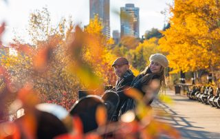 Couple relaxing together during an autumn engagement session with the Edmonton skyline in the background