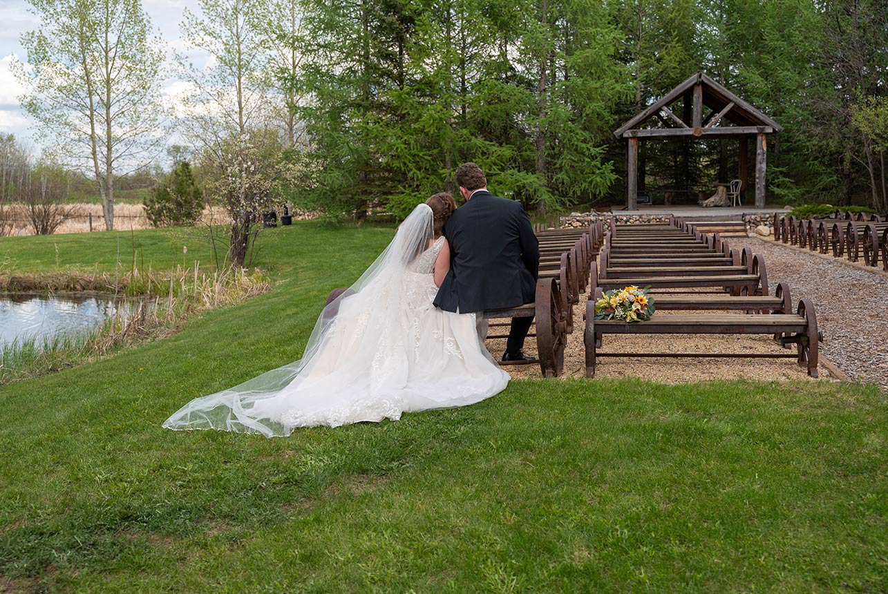 Bride and groom seated together beside the outdoor ceremony space at Lions Garden