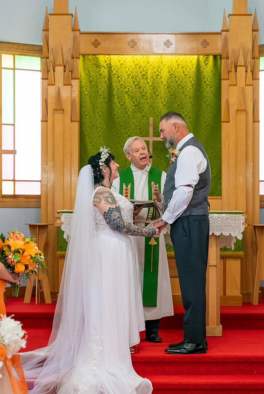 Trudy and Byron standing at the altar during their intimate church wedding ceremony in Leduc County.