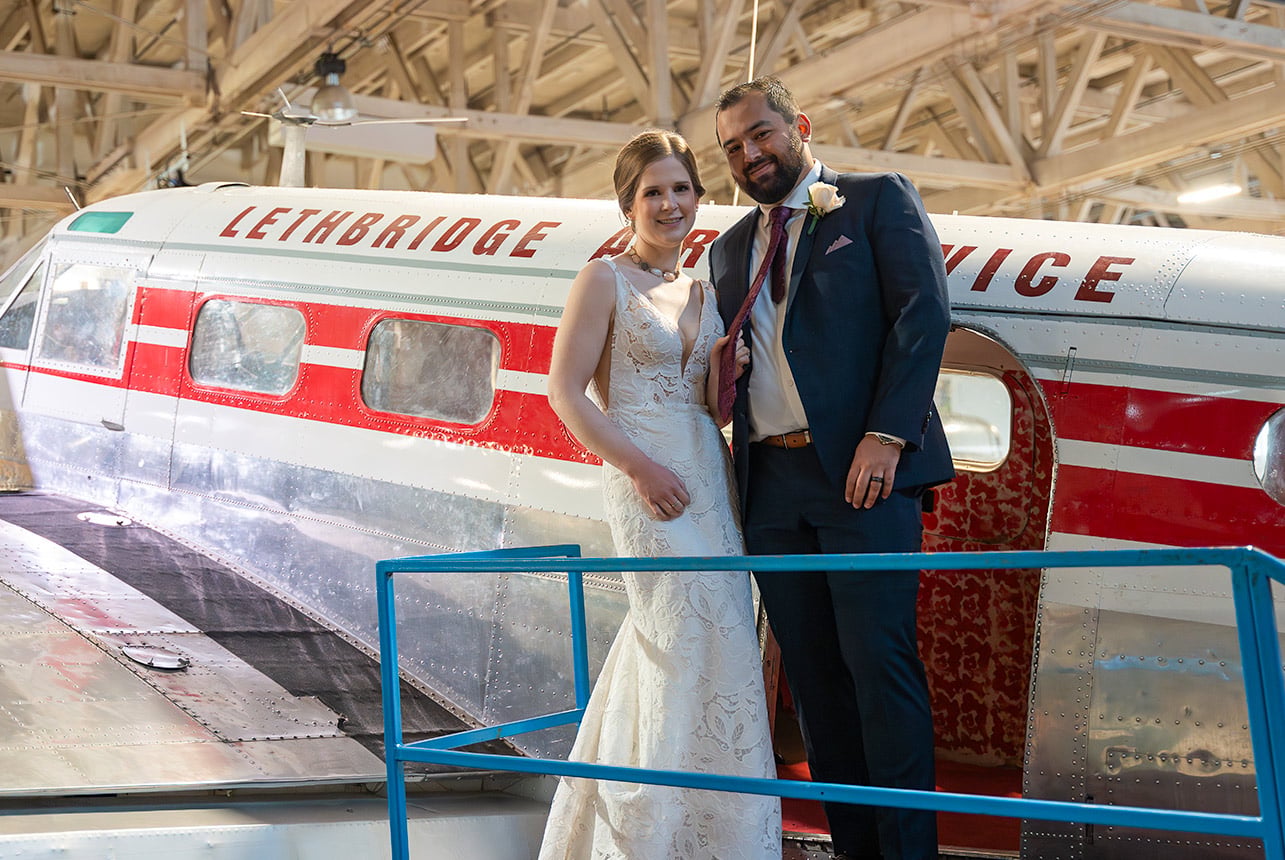 Bride and groom portrait beside an aircraft at Alberta Aviation Museum