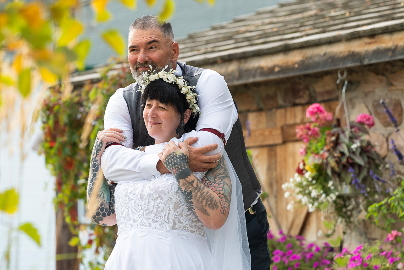 Trudy and Byron embracing during their wedding portraits in Leduc.