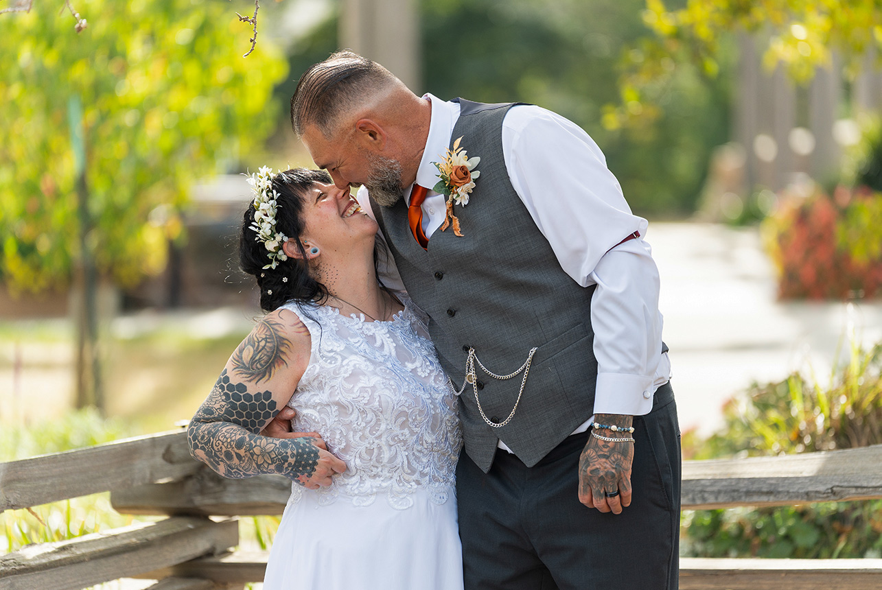 Trudy and Byron sharing a kiss during their outdoor wedding portraits.