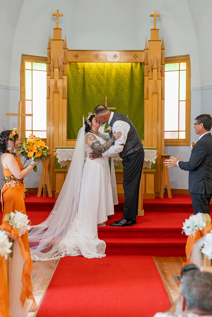 Trudy and Byron sharing a kiss during their wedding ceremony at St. Paul’s Lutheran Church in Rolly View.