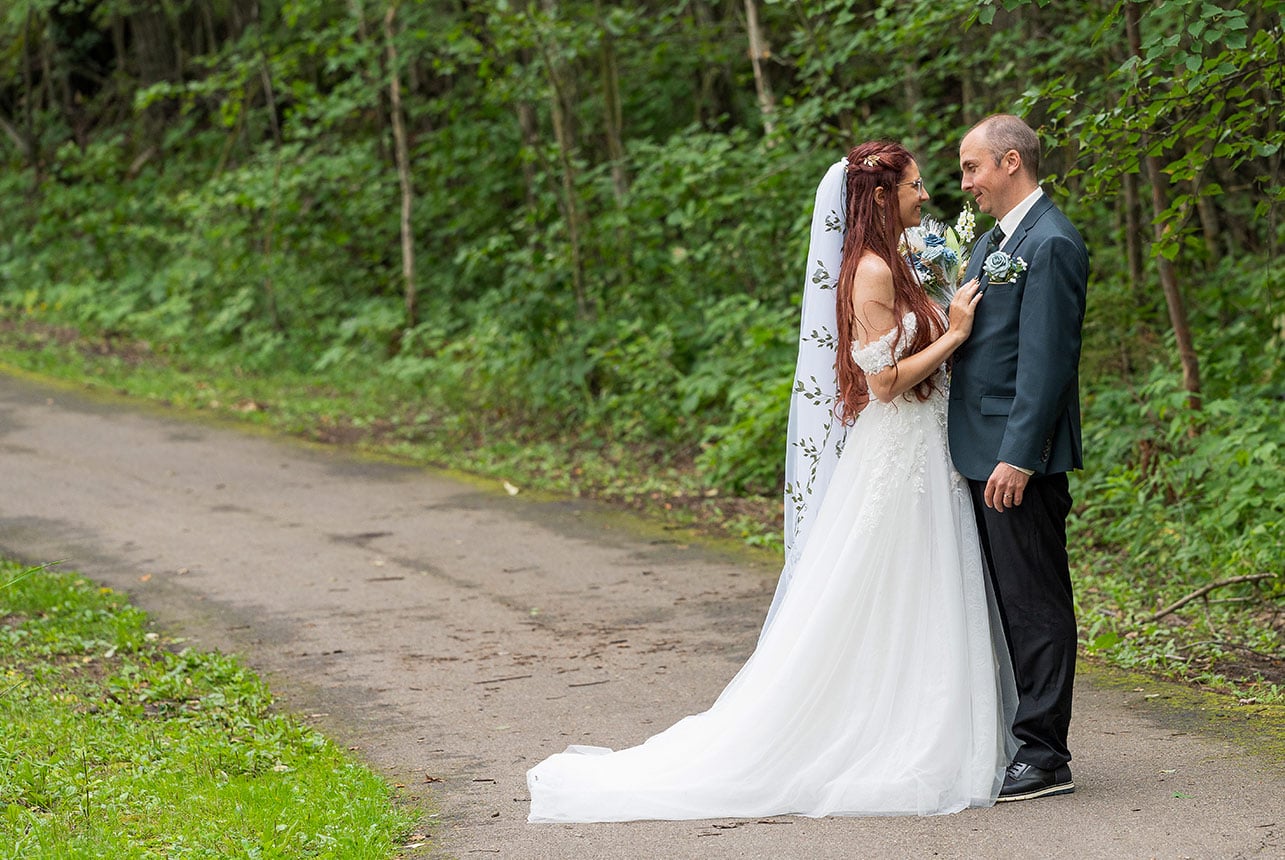 Bride and groom standing together for forest wedding portraits at Elk Island National Park