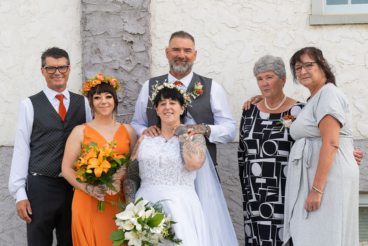 Trudy and Byron posing with family after their church wedding ceremony.