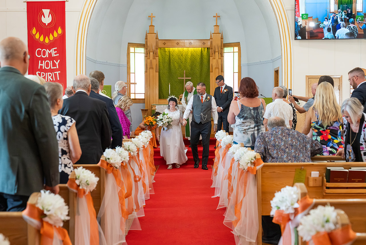 Trudy and Byron walking back down the aisle after their wedding ceremony at St. Paul’s Lutheran Church.