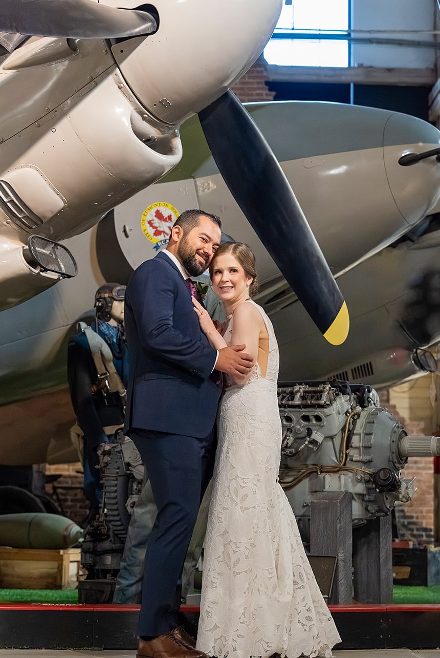 Emma and Braedon beside a historic aircraft at Alberta Aviation Museum