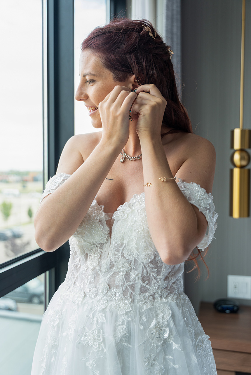 Bride getting ready by the window at Sandman Signature Sherwood Park