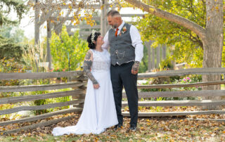 Trudy and Byron standing together for wedding portraits at Stone Barn Garden and Cultural Village in Leduc, Alberta.