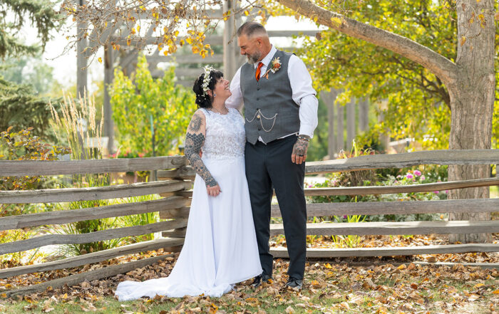 Trudy and Byron standing together for wedding portraits at Stone Barn Garden and Cultural Village in Leduc, Alberta.