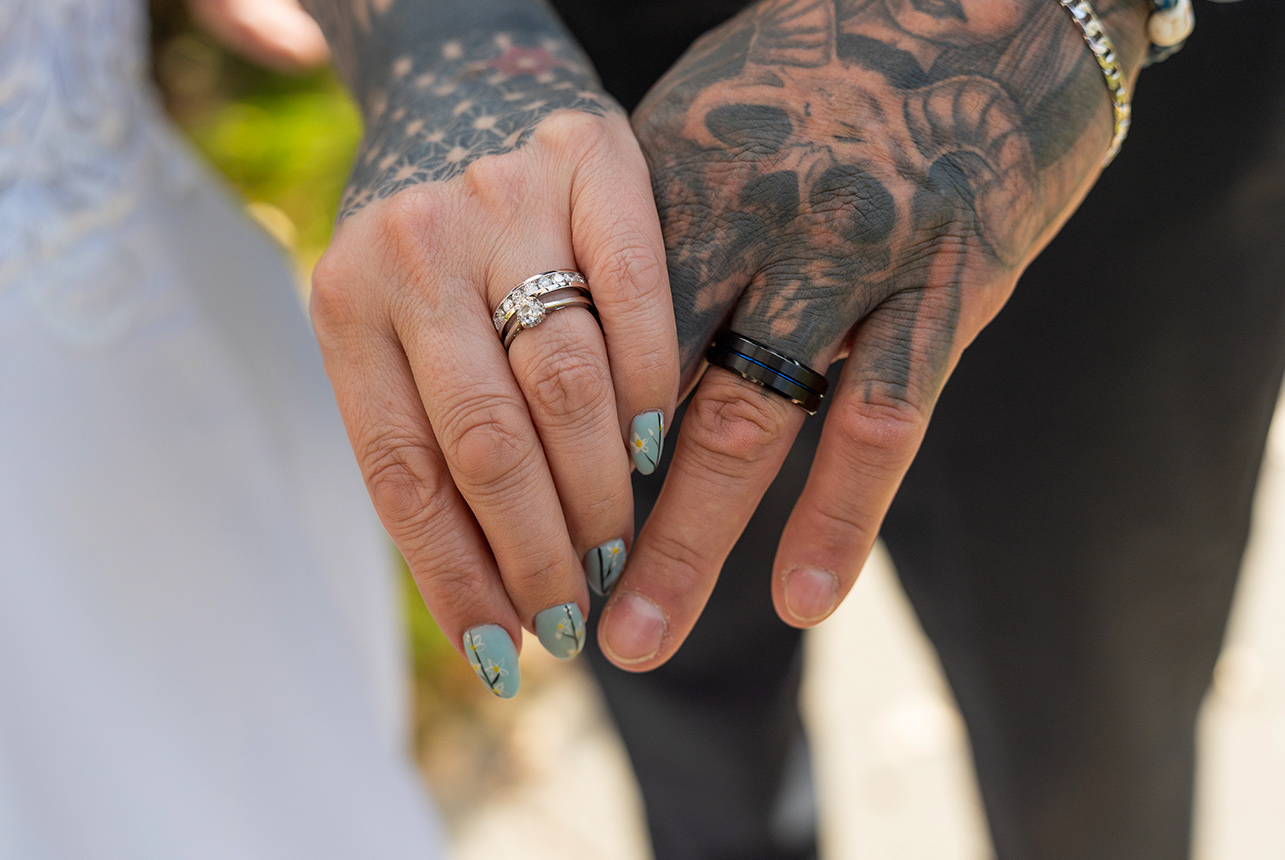 Close-up of Trudy and Byron’s hands and wedding rings during their portrait session.